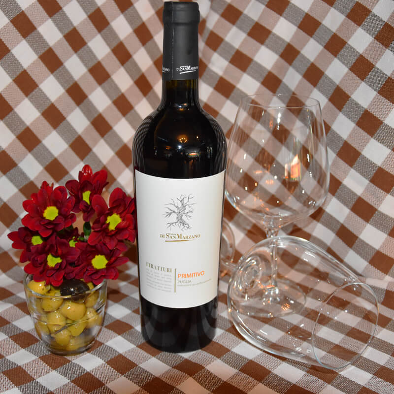Die Weinsorte Feudi di San Marzano - I Tratturi Primitivo Puglia mit zwei Gläsern auf einem Tisch